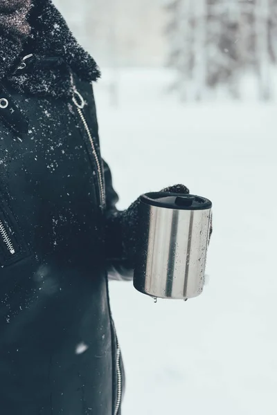 Teilansicht einer Frau mit Thermobecher und Heißgetränk an einem Wintertag — Stockfoto