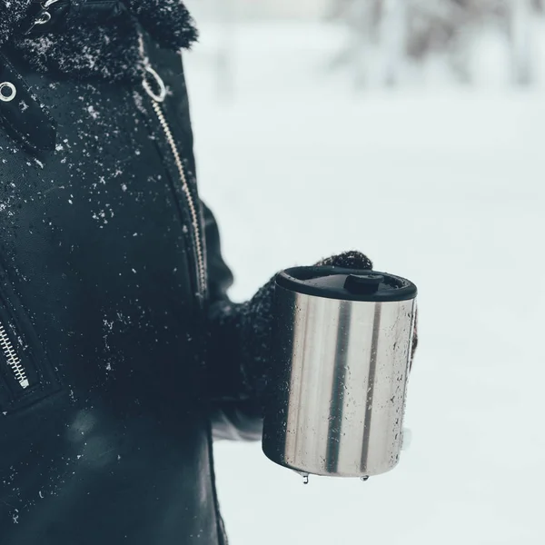 Partial view of woman holding thermocup with hot drink on winter day — Stock Photo