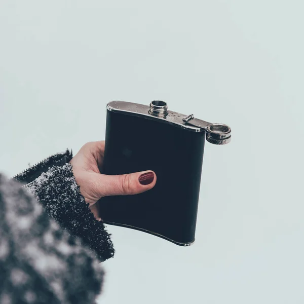 Tiro recortado de la mujer sosteniendo matraz en la mano en el día de invierno — Stock Photo