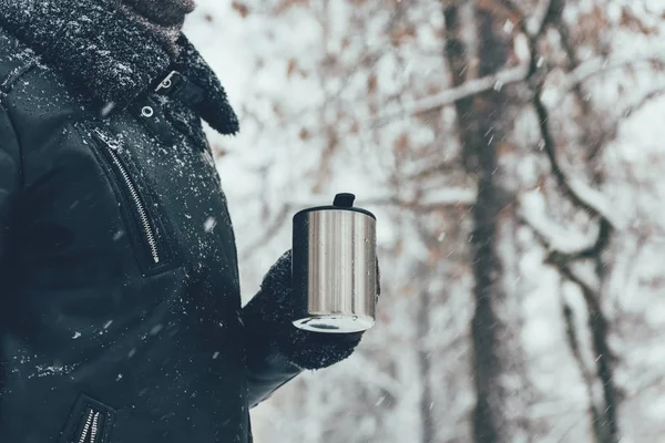 Partial view of woman holding thermocup with hot drink on winter day — Stock Photo