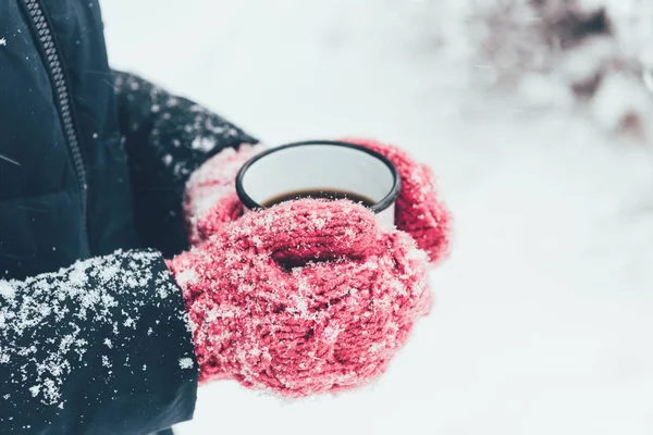 Tiro recortado de la mujer sosteniendo la taza de té en las manos en el día de invierno - foto de stock