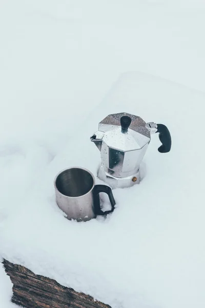 Close up view of cup and coffee maker in snow — Stock Photo