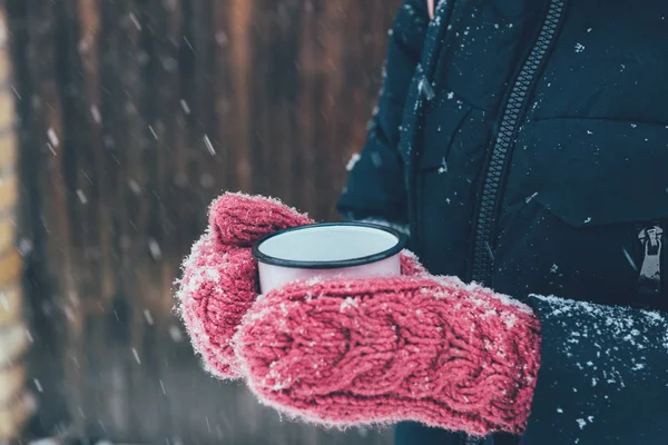Tiro recortado de la mujer sosteniendo la taza de té en las manos en el día de invierno - foto de stock