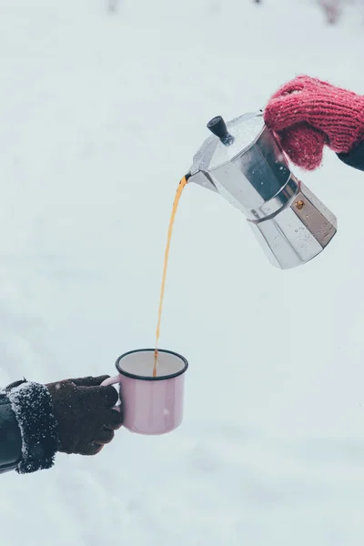 Vue partielle de l'homme versant du café chaud dans une tasse le jour d'hiver — Photo de stock