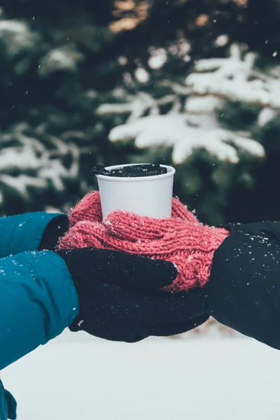 Teilansicht eines Paares, das Thermobecher mit Heißgetränk im Winterwald zusammenhält — Stockfoto