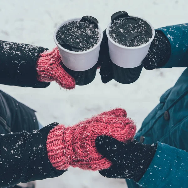 Частковий вид пари з гарячими напоями тримає руки на вулиці взимку — стокове фото
