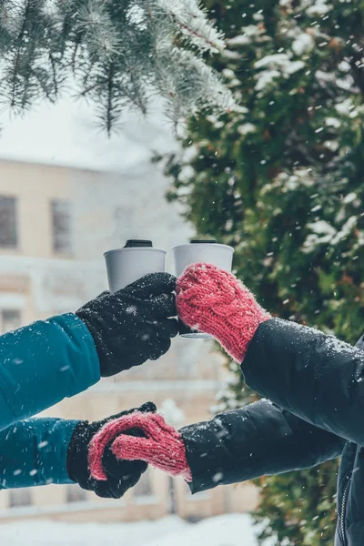 Partial view of couple with hot drinks holding hands on street in winter — Stock Photo