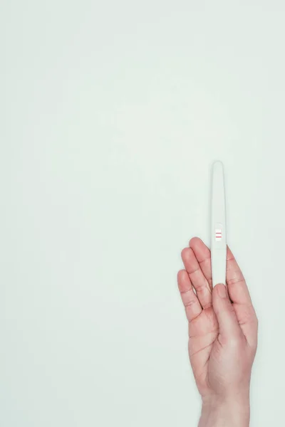 Partial view of woman with pregnancy test in hand isolated on grey — Stock Photo