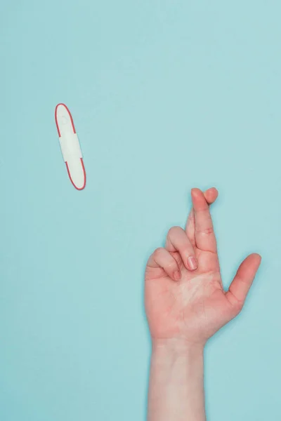 Abgeschnittene Aufnahme der weiblichen Hand und Schwangerschaftstest isoliert auf blau — Stockfoto