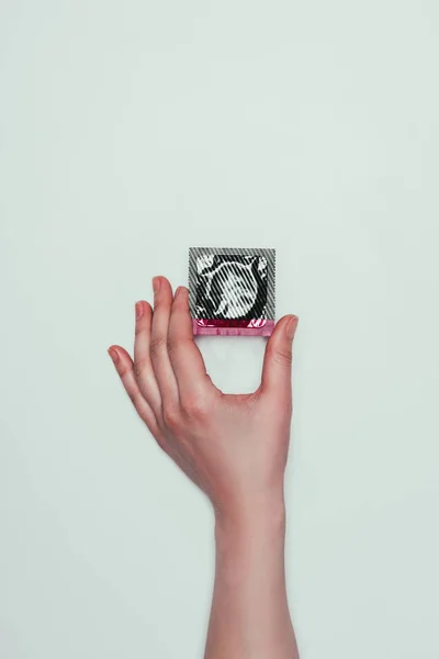 Schnappschuss von Frau mit Kondom in der Hand isoliert auf grau — Stockfoto