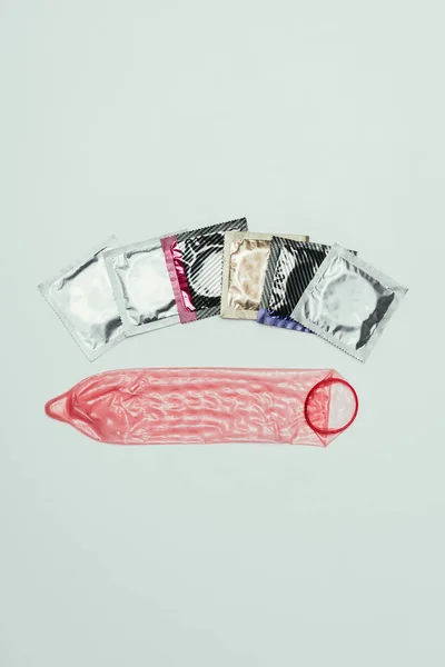 Top view of arrangement of condoms isolated on grey, safety concept — Stock Photo