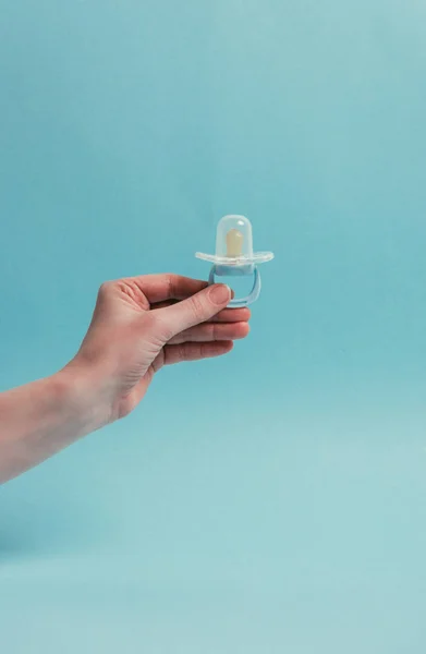 Cropped shot of woman holding pacifier isolated on blue — Stock Photo