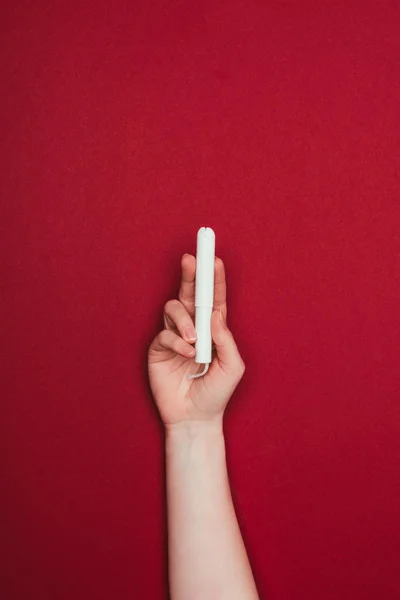 Tiro cortado de mulher segurando tampão na mão isolado no vermelho — Fotografia de Stock