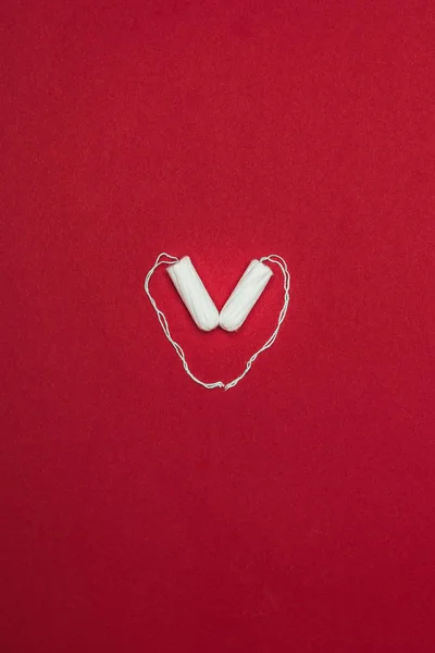 Top view of arranged in heart menstrual tampons isolated on red — Stock Photo
