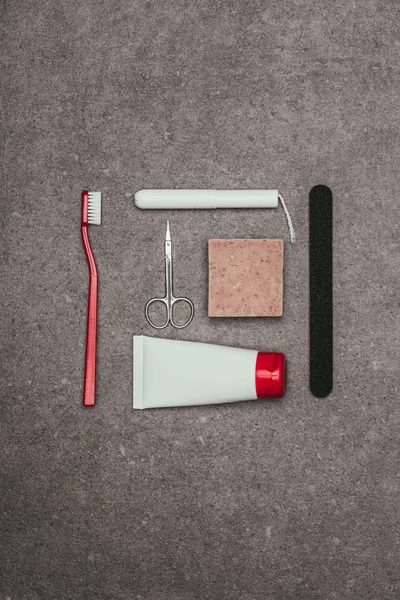 Top view of arrangement of various feminine hygiene supplies on grey surface — Stock Photo