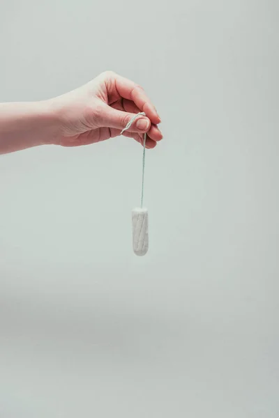 Tiro recortado de mujer sosteniendo tampón en mano aislado en gris - foto de stock