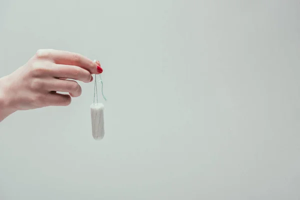 Cropped shot of woman holding tampon in hand isolated on grey — Stock Photo