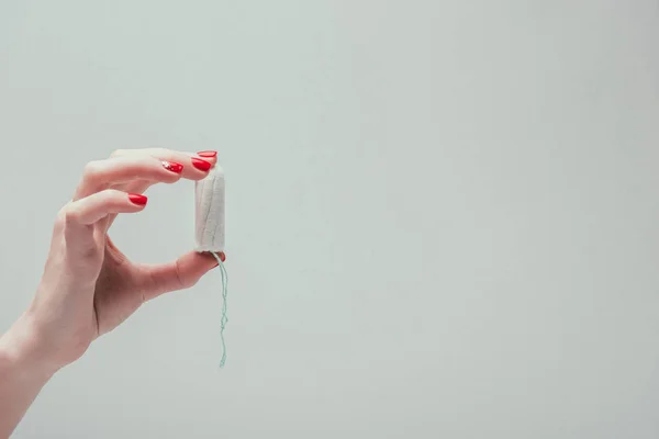 Cropped shot of woman holding tampon in hand isolated on grey — Stock Photo