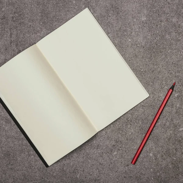 Vista de cerca del cuaderno en blanco y el marcador en la superficie gris - foto de stock