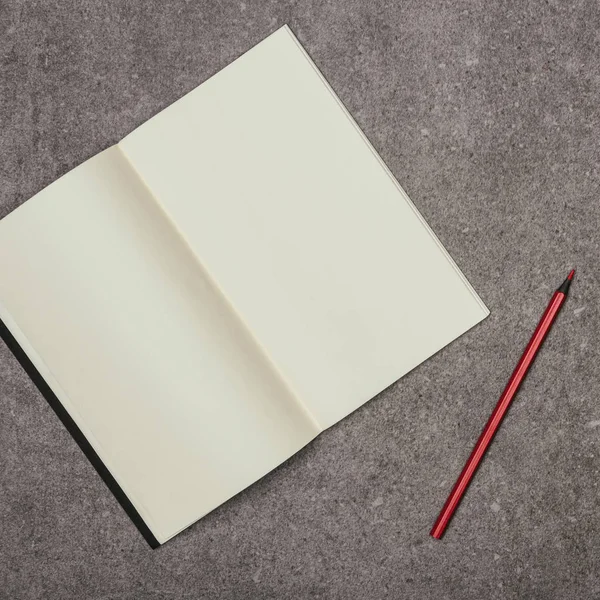 Vista de perto de notebook em branco e marcador na superfície cinza — Fotografia de Stock