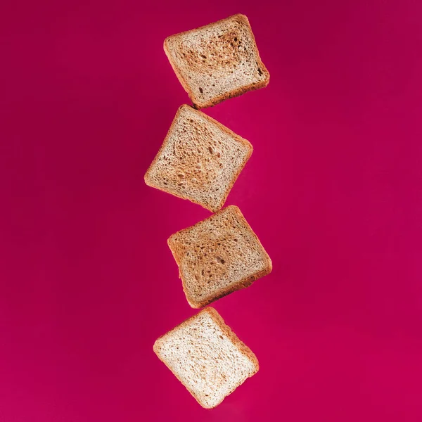 Vue rapprochée des toasts lévitants isolés sur rose — Photo de stock