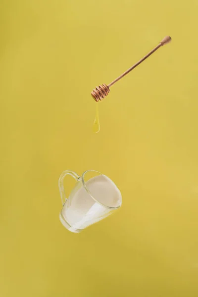 Close up view of levitating cup of milk and honey — Stock Photo