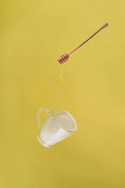 Vista de cerca de la taza levitante de leche y miel - foto de stock