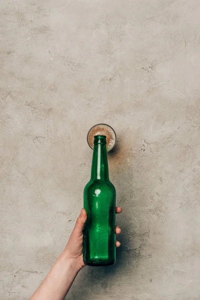 Close-up view of hand pouring drink in glass on light background — Stock Photo