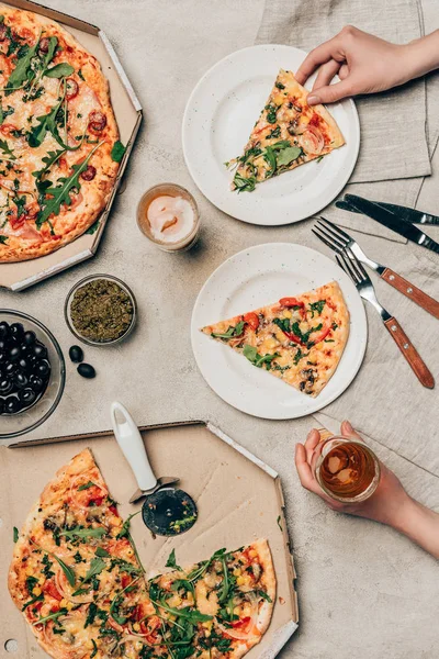 Nahaufnahme einer Frau beim Abendessen mit Pizza und Getränk auf hellem Hintergrund — Stockfoto