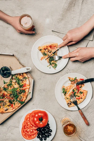 Vista ravvicinata di amici che condividono pizza e bevande su sfondo chiaro — Foto stock