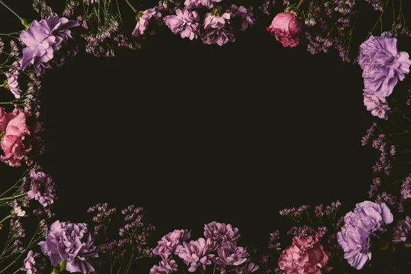 Beau cadre floral en fleurs roses et violettes isolé sur noir — Photo de stock