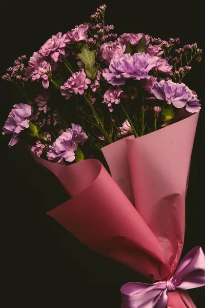 Vista close-up de belo buquê floral de flores rosa concurso com fita isolada em preto — Fotografia de Stock