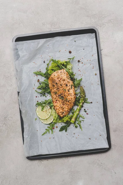 Top view of healthy meat with arugula, lime and asparagus on baking paper — Stock Photo
