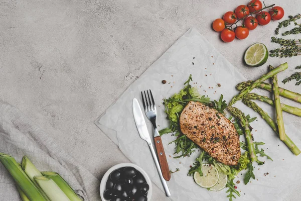 Blick von oben auf leckeres gesundes Backfleisch mit Gemüse auf grau — Stockfoto