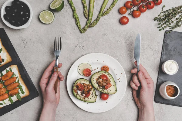 Teilweise Ansicht der Person, die köstliche gesunde Mahlzeit mit biologischem Obst und Gemüse isst — Stockfoto