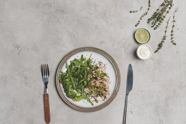 Vista superior de refeição saudável com carne fatiada e legumes verdes com molho e limão em cinza — Fotografia de Stock