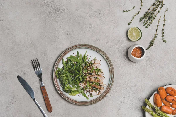 Draufsicht auf gesunde Mahlzeit mit Scheibenfleisch und grünem Gemüse auf grau — Stockfoto