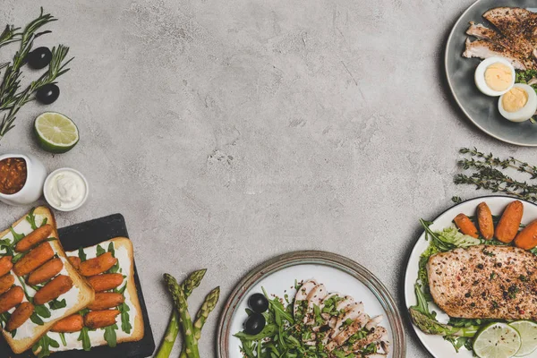 Вид зверху на різні свіжі здорові страви з органічних інгредієнтів на сірий — стокове фото