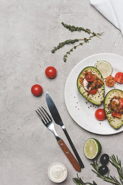Vista superior de la comida gourmet saludable con aguacate, lima y tomates en gris - foto de stock