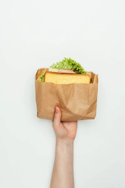 Image recadrée d'une femme tenant un sandwich dans un sac en papier isolé sur blanc — Photo de stock