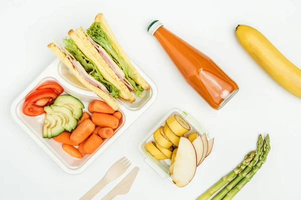 Vue de dessus des sandwichs, fruits et légumes dans des boîtes à lunch isolées sur blanc — Photo de stock