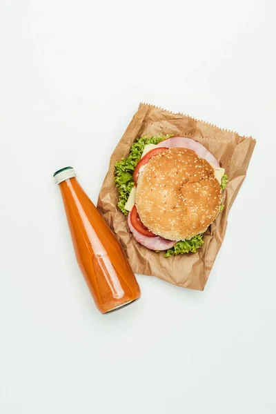 Draufsicht auf Saft mit Burger auf Papiertüte isoliert auf Weiß — Stockfoto