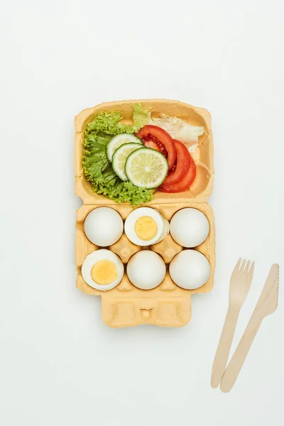 Top view of vegetables and eggs on egg tray isolated on white — Stock Photo