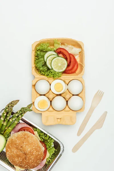 Top view of eggs with vegetables and burger isolated on white — Stock Photo