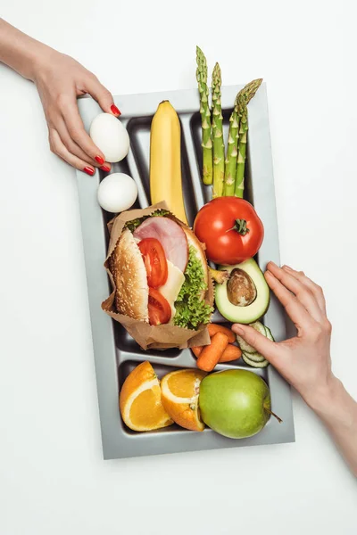 Cropped image of women taking food from tray isolated on white — Stock Photo