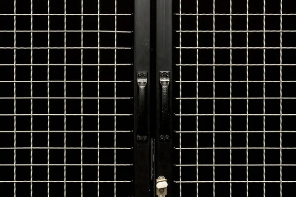Puertas negras con asas y gravilla metálica - foto de stock