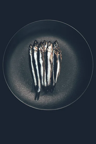 Top view of pile of fish in frying pan isolated on black — Stock Photo