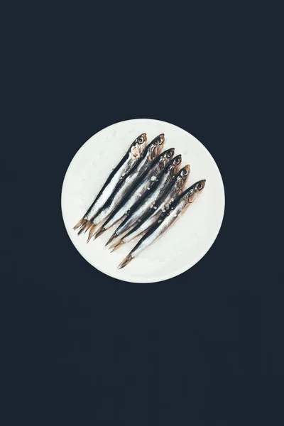 Top view of salted pile of fish in plate isolated on black — Stock Photo