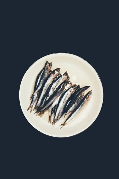 Вид сверху груды рыбы на тарелке, изолированной на черном — стоковое фото