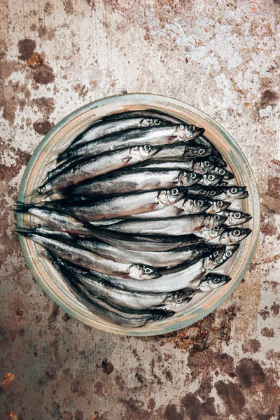 Vista dall'alto di mucchio di pesce su piatto su superficie rustica — Foto stock